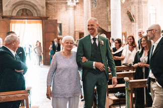 Sposo sorridente percorre la navata tra gli invitati