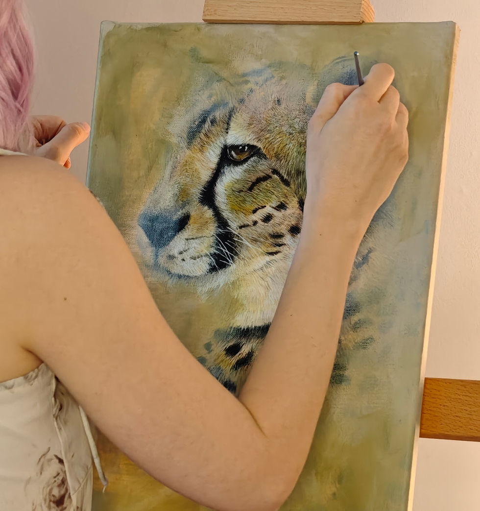 Person malt auf einer Leinwand ein Gepardenporträt im Atelier, mit Pinsel in der rechten Hand; ruhige, konzentrierte Stimmung.