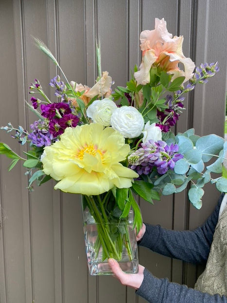Large yellow statement flower arrangement with pink, purple, and green flowers mixed in.