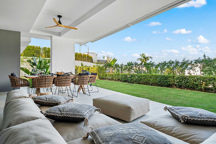 Stijlvol overdekt terras met loungeset en privétuin van een luxe appartement in Soul Marbella