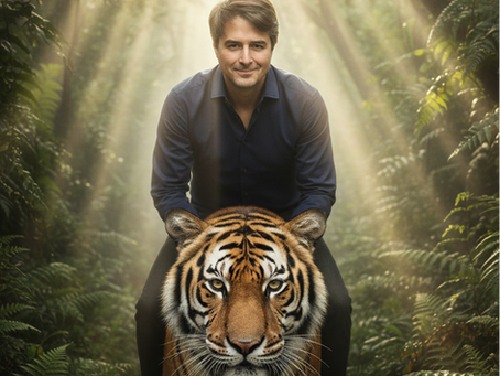 Man in navy shirt smiling, sitting on a tiger in a sunlit jungle with rays filtering through trees, surrounded by lush greenery.