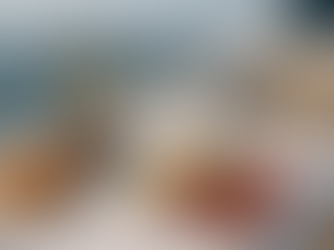 Elegant yacht catering setup in Miami featuring a gourmet charcuterie board with cheeses, cured meats, olives, croissants, and canapés on a white table overlooking the ocean.