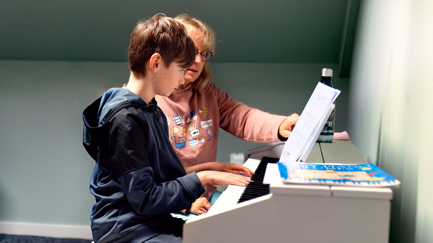 Student practicing basic piano techniques at Encore Music and Wellness Centre.