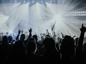 Une foule en liesse à un concert nocturne, générant une pollution sonore et lumineuse.