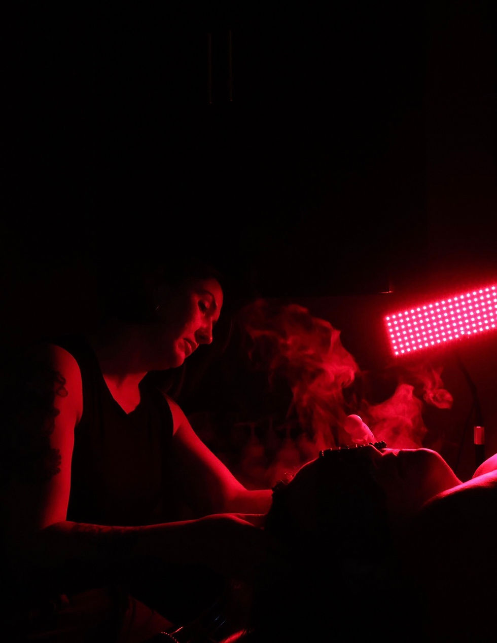 a trichologist performing a scalp facial in a dark room with red LED