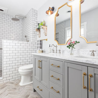 Bright bathroom with white tile, double vanity and gold fixtures