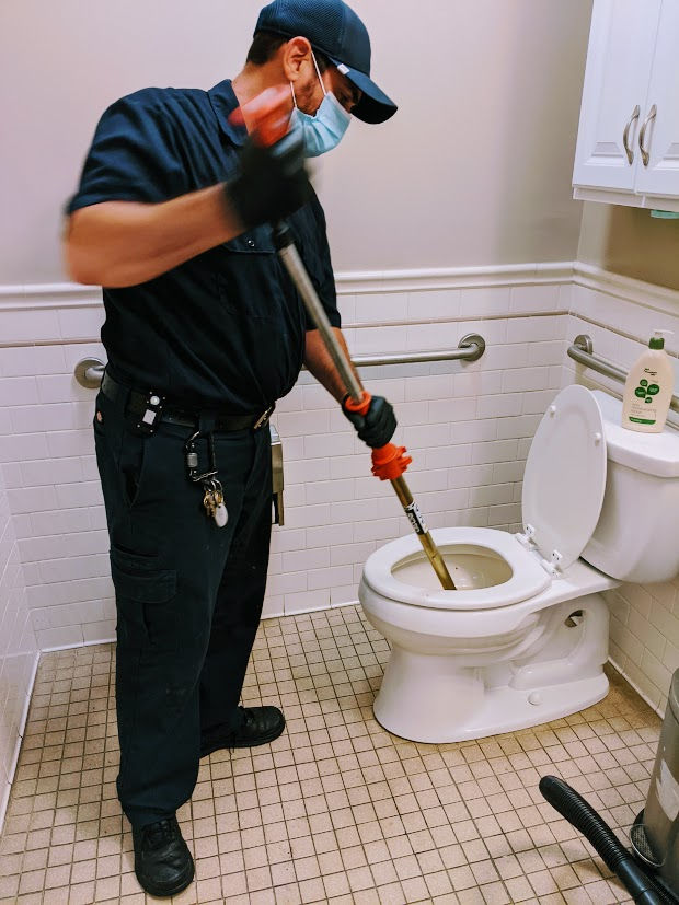 Plumber doing toilet drain cleaning