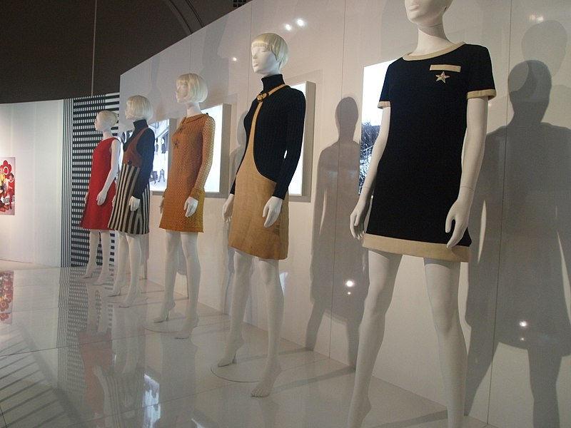 (Alt Text: Five mannequins on display wearing various Mary Quant 1960s mini dresses, from left to right colours of the dresses are, red, black and white strips, camel, black and beige and black and cream)