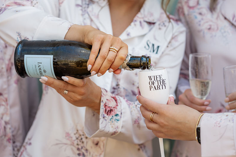 bride and bridesmaids with champagne on wedding day