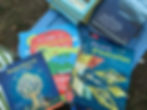 scattered stack of elin kelsey's published children's books with the covers overlapping and titles in various languages