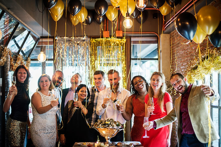 Group celebrating in festive room with gold and black balloons. Everyone is smiling and holding champagne glasses. Joyful party vibe. Group celebrating in festive room with gold and black balloons. Everyone is smiling and holding champagne glasses. Joyful party vibe.