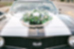 Greenery wreath sitting on top of sports car hood