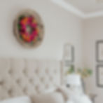 Vibrant pink wreath displayed above a bed
