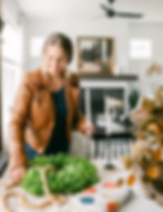 Women arranging table decor including a greenery wreath