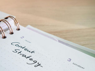 grid notebook with the words "content strategy" written on it