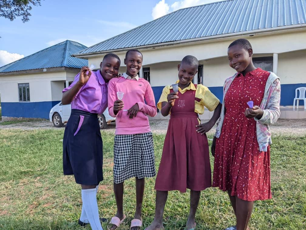 Junge Mädchen stehen mit Menstruationstassen – Präsentation von Menstruationsprodukten.
