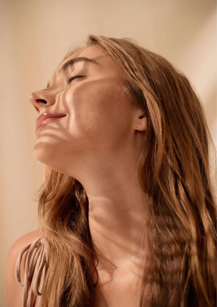 Femme aux cheveux blonds, visage serein, lumière douce