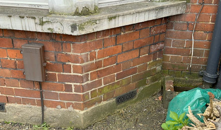Crack in the external brickwork of a London house beside a downpipe
