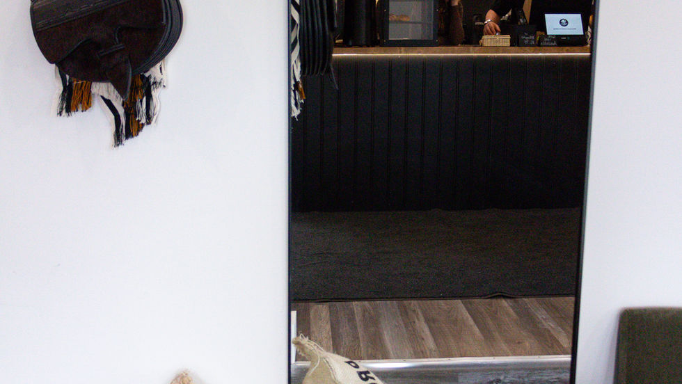Cafe interior with mirror and hanging bag.