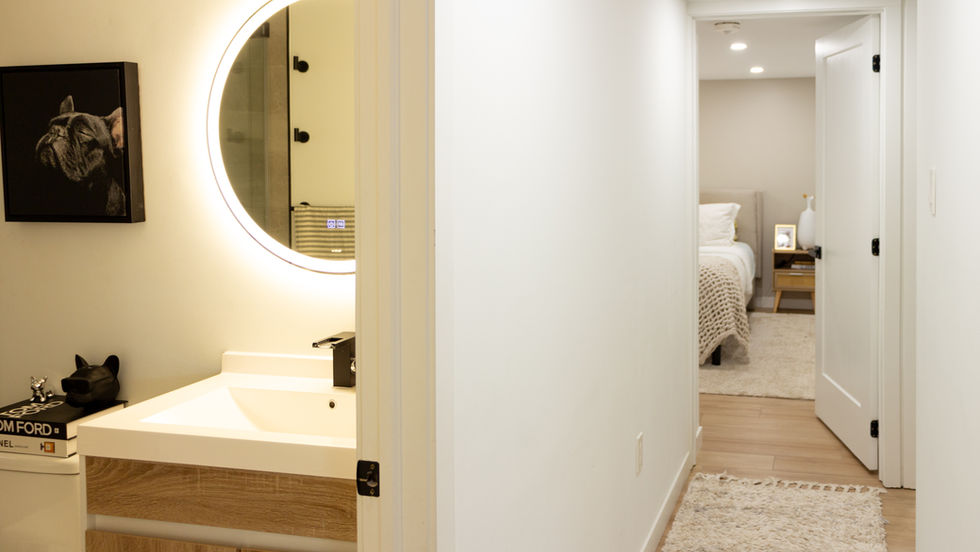 Modern bathroom with circular mirror and minimalist design.