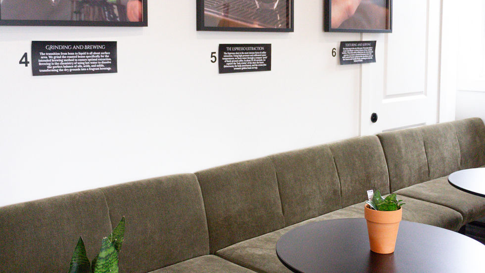 Cozy cafe interior with green sofa and wall art.