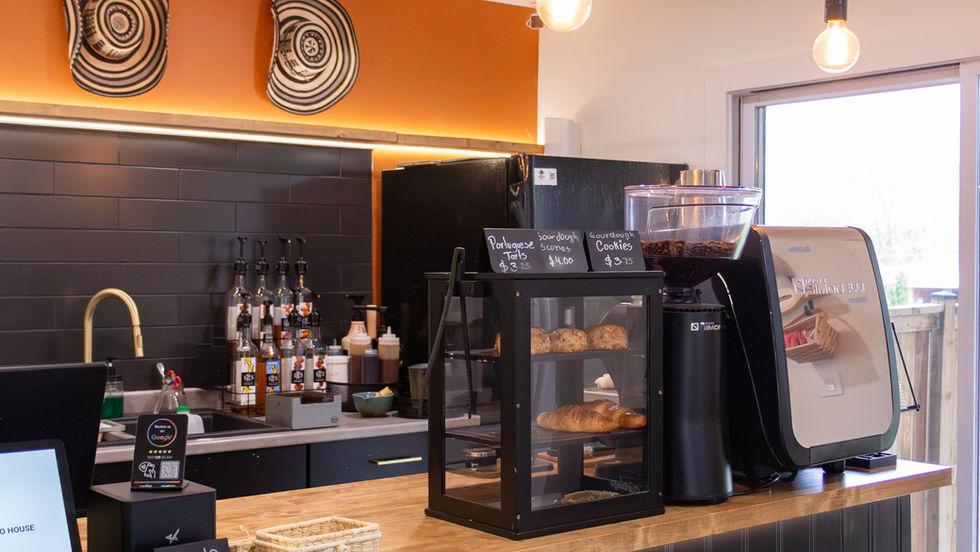 Modern coffee shop counter with pastries and equipment.