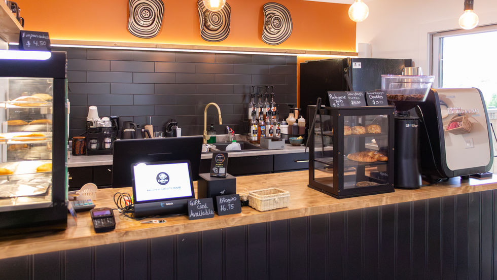 Coffee shop counter with pastries and equipment.
