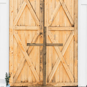 sliding barn doors with cross in front wedding ceremony site at barn wedding venue