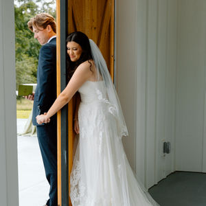 bride and groom first touch at rustic barn wedding venue