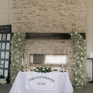 Bride and groom dinning table in front of brick fireplace