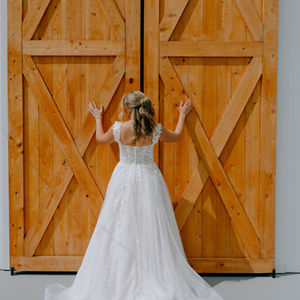 Bridal portrait in front of barn doors White barn rusting wedding venue with barn doors