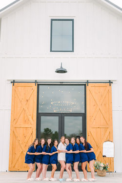 Bridal party at white barn wedding venue with barn sliding doors