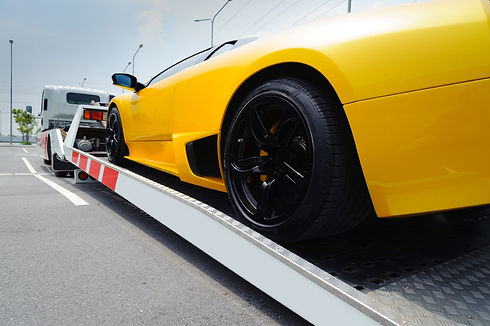 Flat bed truck towing sports car