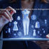 A fashion professional using a tablet interface by QArtSolutions to demonstrate digital asset management fashion, with holographic clothing designs, product images, and pricing icons, showing how digital asset management for fashion brands and retail businesses helps organize, store, and manage digital assets efficiently, improve collaboration, and support faster access to content across marketing, sales, and trade show workflows