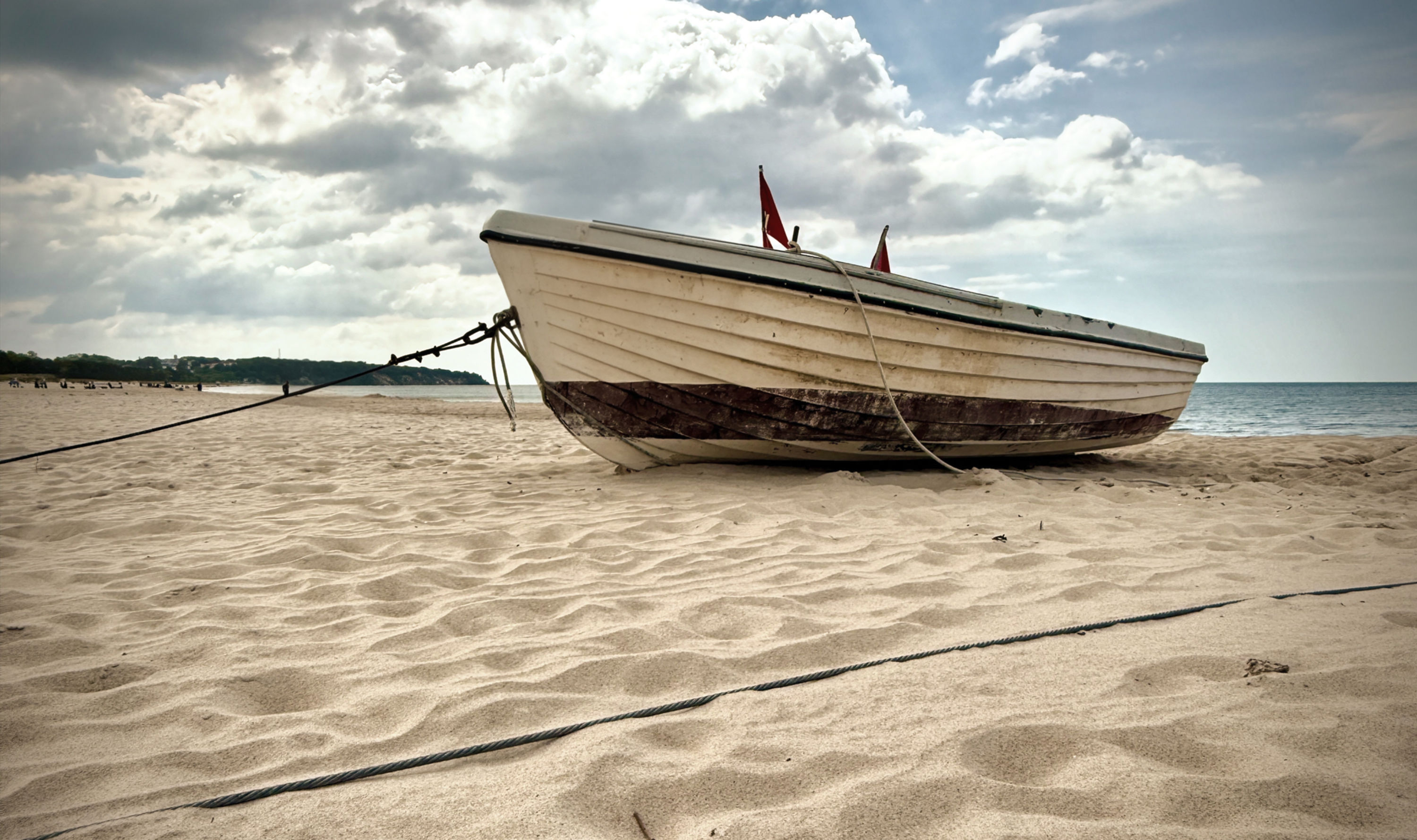 Ein Strand mit Blick auf das Meer und einen Leuchtturm.