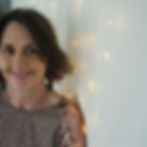 Image of Megan Gallagher taken by Kerry Hodge, Megan is standing against the wall, smiling at the camera
