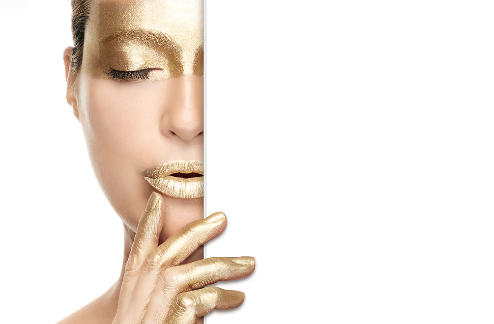 Gold beauty makeup and nail art concept with a half portrait of a woman wearing gold cosme