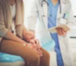 Doctor holding wrist of female patient.