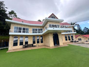 Front view of The White House with landscaped lawn and mountain setting