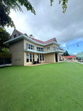 Side view of The White House with expansive lawn and mountain backdrop
