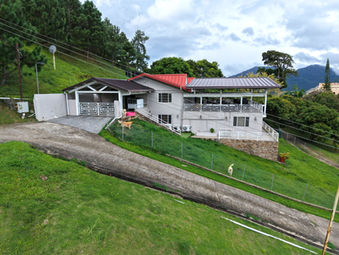 Wide exterior view of Cloud 9 residence with landscaped lawn and mountain backdrop