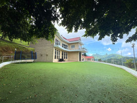 Outdoor lawn beside The White House with Northern Range views beyond