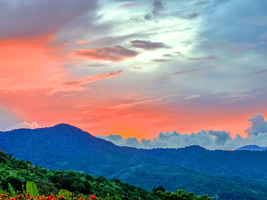 Pink and orange sunset over the Northern Range and tropical landscape at Valli Hai Estate