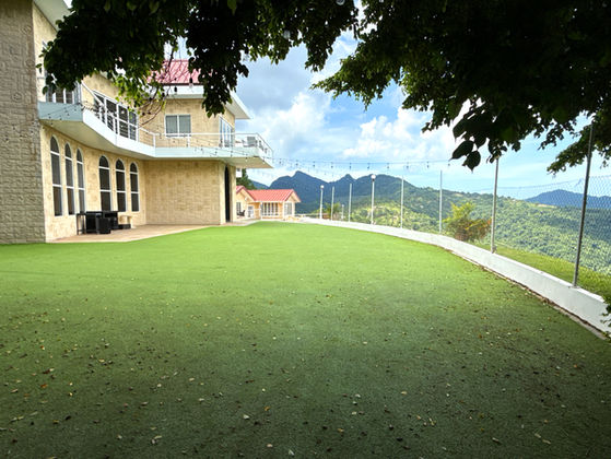 The White House exterior and landscaped lawn with Northern Range views at Valli Hai Estate