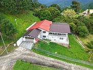 Aerial view of Cloud 9 with red roof, lawn and surrounding greenery