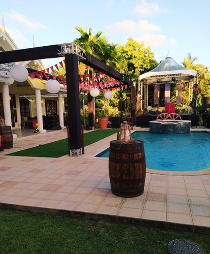 Western-themed poolside event setup with wooden barrels, lanterns and a stage at Shandison Villa