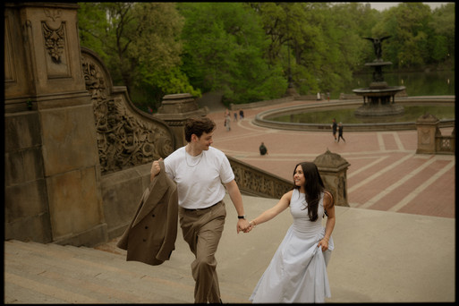 couple running bethesda terrace staircase central park fountain below engagement