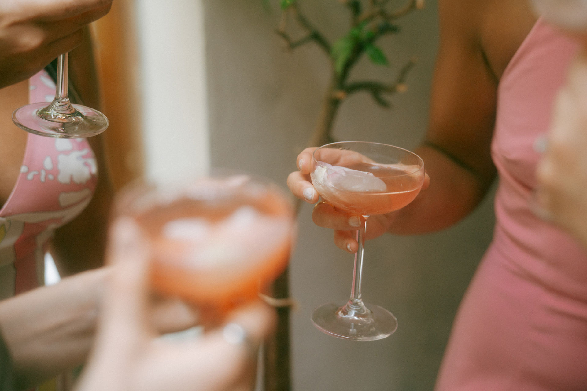 Bridal shower at Palma West Village New York event photography three guests in light outfits holding pink cocktails coupe glasses