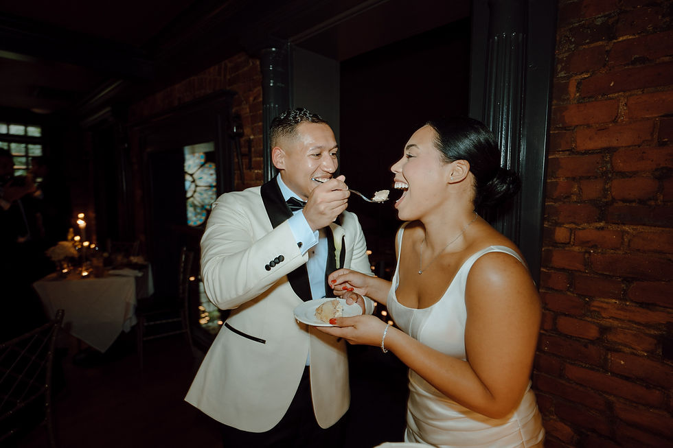 bride and groom laughing during cake cutting at intimate wedding reception