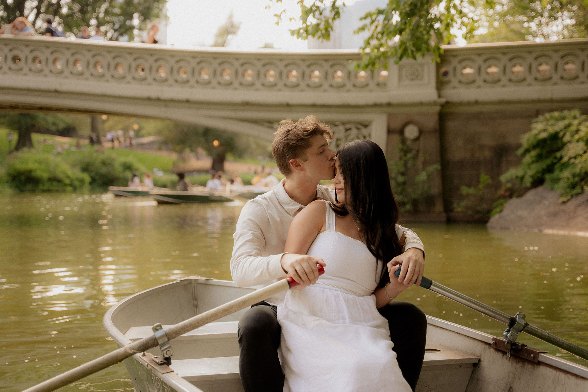 romantic couple kissing rowboat central park lake bow bridge engagement session nyc